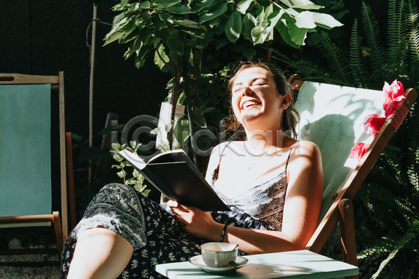 여유 휴식 성인 성인여자한명만 여자 한명 JPG 옆모습 포토 해외이미지 그림자 다리꼬기 독서 들기 상반신 앉기 야외 여행 웃음 주간 책 햇빛 혼자