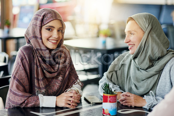여유 함께함 행복 20대 두명 성인 성인여자만 여자 JPG 아웃포커스 포토 해외이미지 라이프스타일 상반신 식당 실내 앉기 응시 이슬람교 카페 탁자