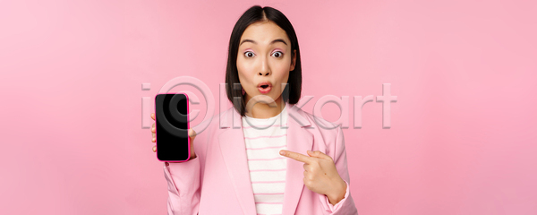 동양인 성인 성인여자한명만 여자 한명 JPG 포토 해외이미지 가리킴 놀람 들기 보여주기 분홍색배경 비즈니스 비즈니스우먼 상반신 스마트폰 응시
