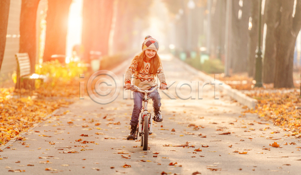 소녀(어린이) 소녀한명만 어린이 여자 한명 JPG 아웃포커스 앞모습 포토 해외이미지 가을(계절) 공원 공원길 나무 미소(표정) 빛 숲 스타일 승차 야외 자전거 전신