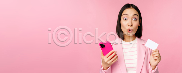 동양인 성인 성인여자한명만 여자 한명 JPG 포토 해외이미지 들기 분홍색배경 비즈니스 비즈니스우먼 상반신 서기 스마트폰 신용카드 응시