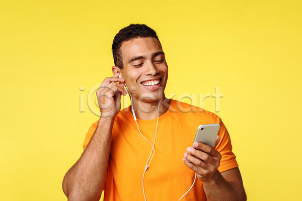 남자 성인 성인남자한명만 한명 JPG 앞모습 포토 해외이미지 들기 상반신 스마트폰 실내 웃음 음악감상 이어폰 착용