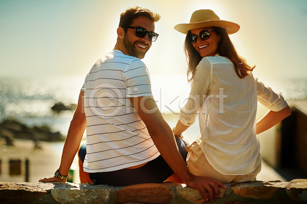 여유 즐거움 함께함 휴식 남자 두명 백인 성인 성인만 여자 JPG 뒷모습 포토 해외이미지 뒤돌아보기 미소(표정) 밀짚모자 바다 상반신 선글라스 앉기 야외 여름(계절) 일몰 주간 커플 하늘 햇빛