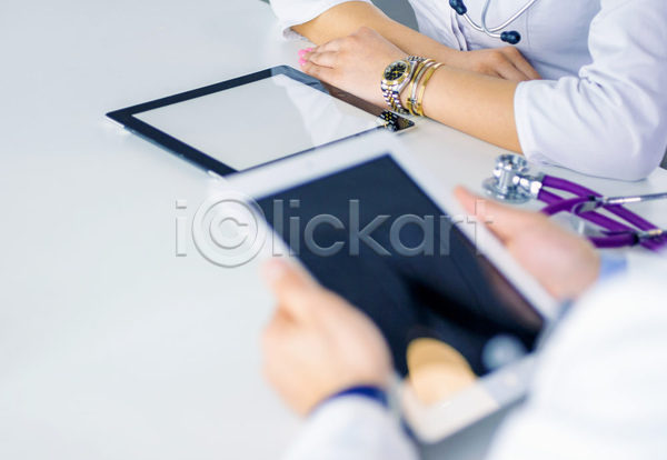 성인 성인여자한명만 신체부위 여자 한명 JPG 소프트포커스 포토 해외이미지 들기 손 실내 의사 의학 책상 청진기 태블릿 확인