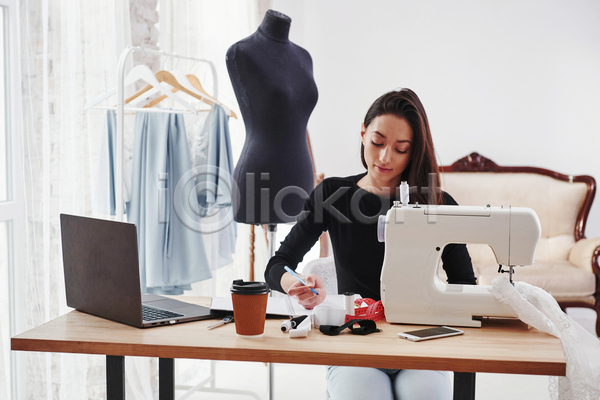 서양인 성인 성인여자한명만 여자 한명 JPG 앞모습 포토 해외이미지 노트북 드레스 마네킹 상반신 실내 앉기 옷걸이 의자 재봉틀 패션디자이너