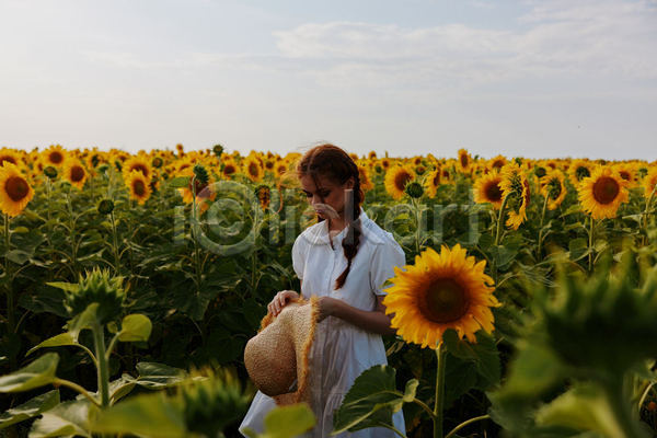 성인 성인여자한명만 여자 한명 JPG 옆모습 포토 해외이미지 꽃밭 내려보기 들기 밀짚모자 상반신 야외 주간 해바라기