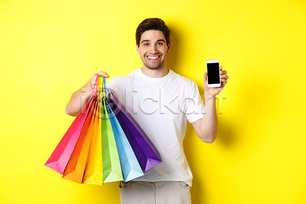 집중 남자 서양인 성인 성인남자한명만 한명 JPG 앞모습 포토 해외이미지 들기 보여주기 사각형 상반신 쇼핑 쇼핑백 스마트폰 웃음 주목 프레임