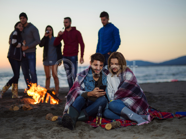 남자 성인 성인만 여러명 여자 JPG 앞모습 포토 해외이미지 담요 덮기 들기 모닥불 서기 앉기 야외 전신 주간 친구 캠핑 커플 해변