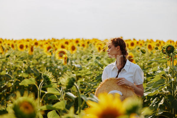 성인 성인여자한명만 여자 한명 JPG 소프트포커스 앞모습 포토 해외이미지 꽃밭 들기 미소(표정) 상반신 야외 여름(계절) 응시 주간 풍경(경치) 해바라기