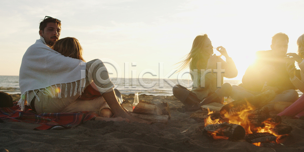 휴식 남자 성인 성인만 여러명 여자 JPG 앞모습 옆모습 포토 해외이미지 기댐 담요 덮기 모닥불 앉기 야외 전신 주간 캠핑 커플 해변 햇빛