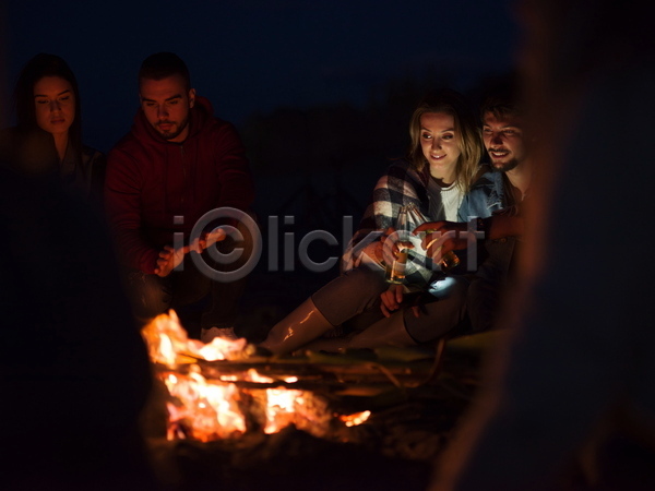 휴식 남자 성인 성인만 여러명 여자 JPG 소프트포커스 앞모습 포토 해외이미지 건배 나뭇가지 들기 모닥불 앉기 야간 야외 어둠 웃음 전신 캠핑 커플