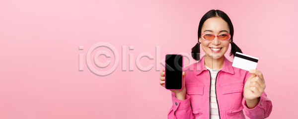 동양인 성인 성인여자한명만 여자 한명 JPG 포토 해외이미지 들기 보여주기 분홍색배경 상반신 서기 선글라스 스마트폰 신용카드