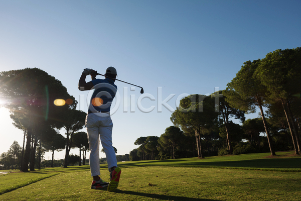 남자 성인 성인남자한명만 한명 JPG 뒷모습 포토 해외이미지 골퍼 골프 골프웨어 골프장 골프채 나무 서기 스윙 야외 역광 전신 주간 하늘 햇빛