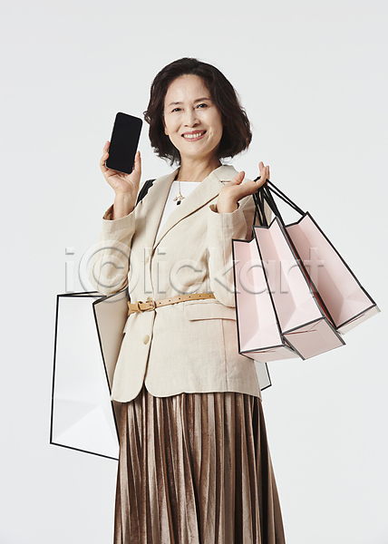 즐거움 60대 노년 노인여자한명만 여자 한국인 한명 JPG 앞모습 포토 들기 미소(표정) 상반신 쇼핑 쇼핑백 스마트폰 스튜디오촬영 실내 실버라이프 우먼라이프 할머니 흰배경