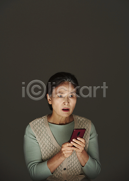 60대 노년 노인여자한명만 여자 한국인 한명 JPG 앞모습 포토 검은배경 놀람 들기 보이스피싱 상반신 서기 스마트폰 스튜디오촬영 실내 실버라이프 심각 피해 할머니