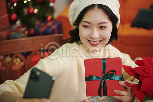 20대 성인 성인여자한명만 여자 한국인 한명 JPG 아웃포커스 앞모습 포토 들기 미소(표정) 상반신 선물 선물상자 셀프카메라 스마트폰 실내 우먼라이프 크리스마스 파티