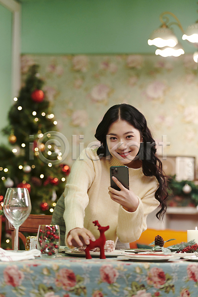 20대 성인 성인여자한명만 여자 한국인 한명 JPG 아웃포커스 앞모습 포토 들기 미소(표정) 사진촬영 상반신 상차림 스마트폰 실내 우먼라이프 잡기 크리스마스 파티
