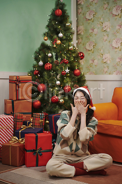 20대 성인 성인여자한명만 여자 한국인 한명 JPG 앞모습 포토 거실 산타모자 선물상자 실내 앉기 양갈래머리 우먼라이프 웃음 입가림 전신 크리스마스 크리스마스트리 파티