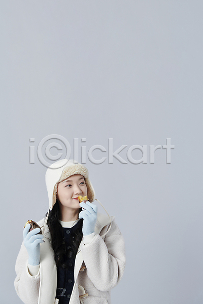 20대 성인 성인여자한명만 여자 한국인 한명 JPG 앞모습 포토 겨울 군고구마 들기 먹기 상반신 스튜디오촬영 실내 털모자 회색배경