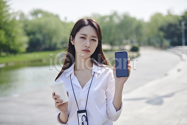 20대 성인 성인여자한명만 여자 한국인 한명 JPG 아웃포커스 앞모습 포토 곤란 공원 들기 보여주기 비즈니스라이프 비즈니스우먼 사원증 상반신 스마트폰 야외 응시 주간 직장인 찡그림 커피 테이크아웃컵
