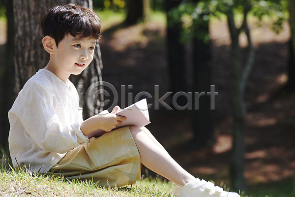 남자 소년 소년한명만 어린이 한국인 한명 JPG 아웃포커스 옆모습 포토 공원 나무 독서 들기 미소(표정) 앉기 야외 여름(계절) 자연 전신 주간 책