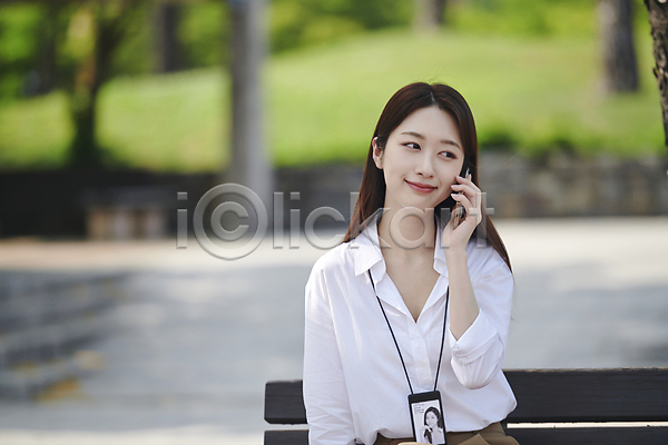 여유 20대 성인 성인여자한명만 여자 한국인 한명 JPG 아웃포커스 앞모습 포토 공원 들기 미소(표정) 벤치 비즈니스라이프 비즈니스우먼 상반신 세미정장 스마트폰 앉기 야외 주간 통화