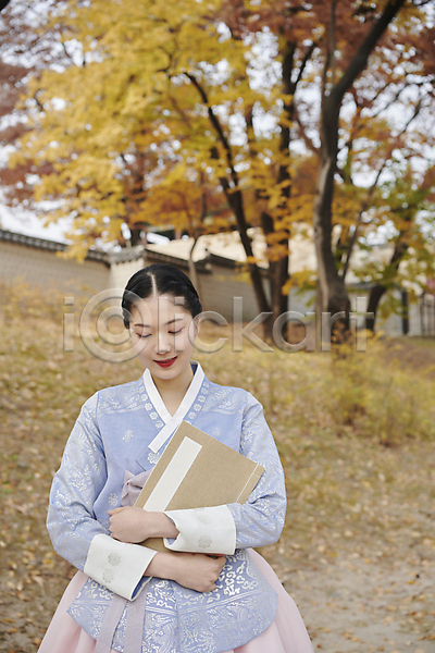 20대 성인 성인여자한명만 여자 한국인 한명 JPG 아웃포커스 앞모습 포토 가을(계절) 경복궁 눈감음 단아함 들기 미소(표정) 상반신 서울 서책 안기 야외 주간 한국전통 한복