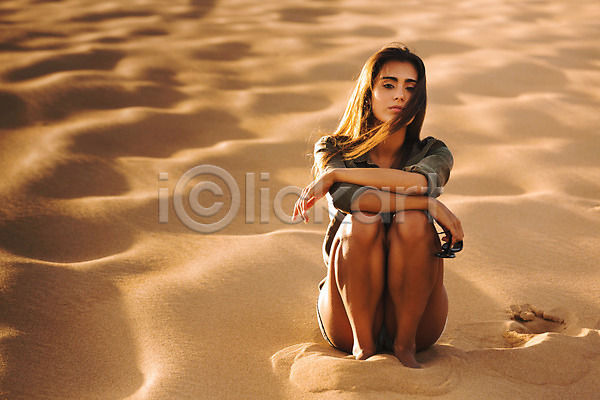 휴식 백인 사람 성인여자한명만 여자 한명 JPG 앞모습 포토 해외이미지 갈색머리 라이프스타일 모래 모래언덕 반바지 백그라운드 사막 스타일 심각 앉기 야외 여름(계절) 자연 전신 카피스페이스 태양 포즈 해외202004
