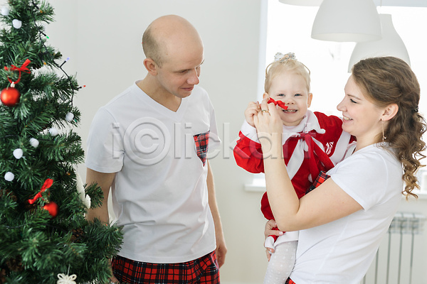 남자 백인 성인 세명 아기 여자 JPG 앞모습 옆모습 포토 해외이미지 가족 들기 리본 미소(표정) 상반신 크리스마스 크리스마스트리 해외202309 휴가