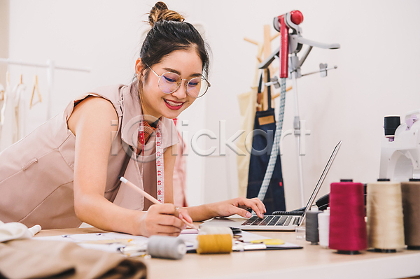 동양인 성인 성인여자한명만 여자 한명 JPG 포토 해외이미지 노트북 들기 디자이너 디자인 미소(표정) 안경낌 업무 연필 옷 작업실 해외202309