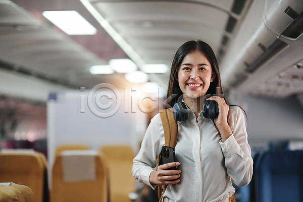 동양인 성인 성인여자한명만 여자 한명 JPG 앞모습 포토 해외이미지 기내 백팩 비행기 상반신 서기 스마트폰 승객 의자 해외202309 헤드셋
