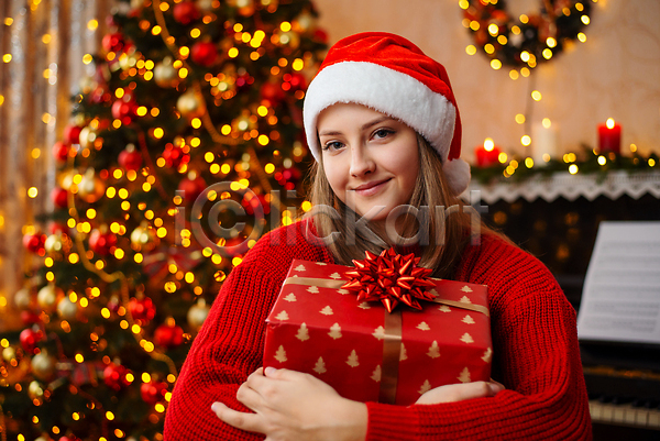 성인 성인여자한명만 여자 한명 JPG 앞모습 포토 해외이미지 12월 산타모자 상반신 선물상자 안기 장식 크리스마스 크리스마스선물 크리스마스트리 해외202309