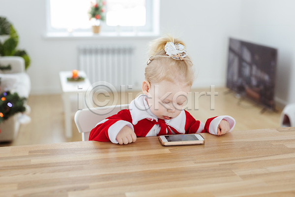 백인 아기 여자 여자아기한명만 한명 JPG 앞모습 포토 해외이미지 가족 상반신 스마트폰 앉기 응시 의자 크리스마스 해외202309 휴가