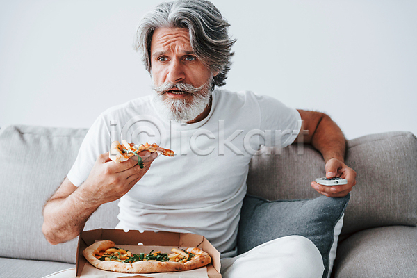 여유 휴식 남자 노년 노인남자한명만 한명 JPG 앞모습 포토 해외이미지 눕기 들기 리모컨 맛있는 먹기 상반신 소파 수염 실내 실버라이프 앉기 피자 할아버지 해외202309