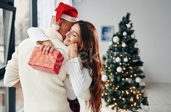 사랑 행복 남자 두명 성인 성인만 여자 JPG 포토 해외이미지 겨울 눈감음 산타모자 상반신 선물상자 안기 커플 크리스마스 크리스마스트리
