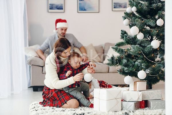 행복 남자 성인 소녀(어린이) 아기 어린이 여러명 여자 JPG 포토 해외이미지 가족 거실 겨울 산타모자 선물상자 소파 앉기 장식 카펫 크리스마스 크리스마스트리