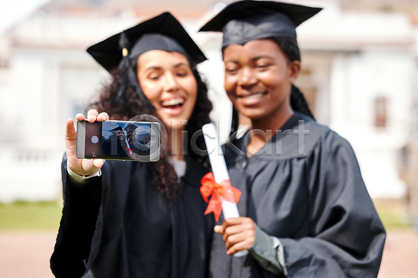 두명 백인 성인 성인여자만 여자 흑인 JPG 앞모습 포토 해외이미지 들기 미소(표정) 사진촬영 상반신 스마트폰 졸업가운 졸업생 졸업식 졸업장 학교 학사모 해외202310