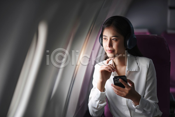 동양인 성인 성인여자한명만 여자 한명 JPG 앞모습 포토 해외이미지 기내 비행기 상반신 스마트폰 승객 앉기 의자 해외202310 헤드셋