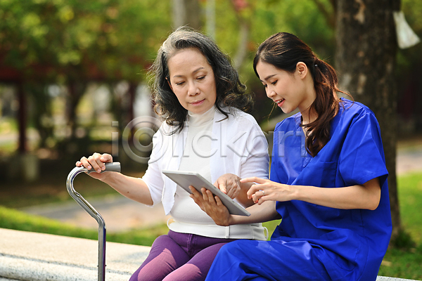 노년 두명 성인 성인여자만 여자 JPG 포토 해외이미지 가리킴 공원 나무 벤치 상반신 앉기 야외 의사 진료 태블릿