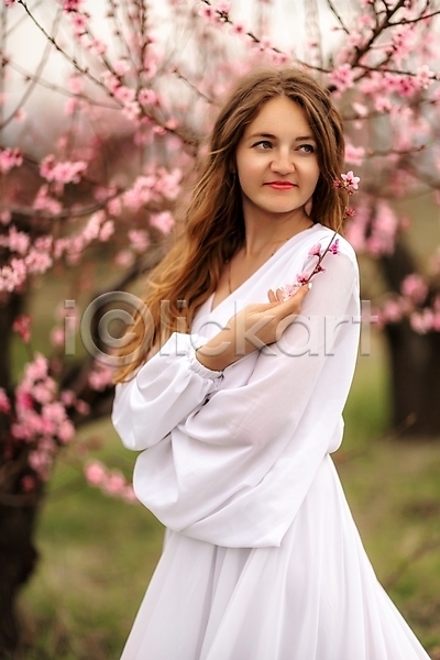성인 성인여자한명만 여자 한명 JPG 포토 해외이미지 나뭇가지 드레스 들기 미소(표정) 벚나무 봄 뷰티 상반신 야외 해외202310