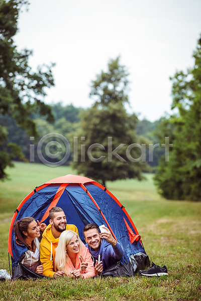 우정 행복 20대 남자 백인 성인 성인만 여러명 여자 JPG 포토 해외이미지 라이프스타일 미소(표정) 스마트폰 시골 야외 자연 장비 초록색 캠핑 캠핑장 텐트 풍경(경치) 해외202004