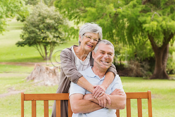 사랑 여유 함께함 행복 60대 70대 남자 노년 노인만 두명 백인 성인 여자 JPG 포토 해외이미지 건강 공원 나무 라이프스타일 미소(표정) 벤치 서기 앉기 야외 응시 초록색 커플 포옹 해외202004 회색