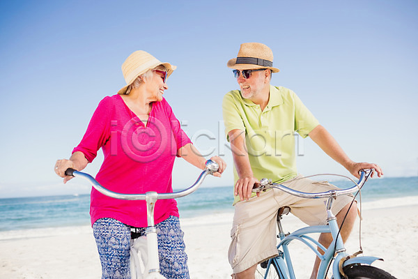 사랑 함께함 행복 60대 70대 남자 노년 노인만 두명 백인 여자 JPG 포토 해외이미지 맑음 모래 물 미소(표정) 밀짚모자 바다 선글라스 승차 야외 여름(계절) 운동 자전거 커플 파도 해외202004 휴가