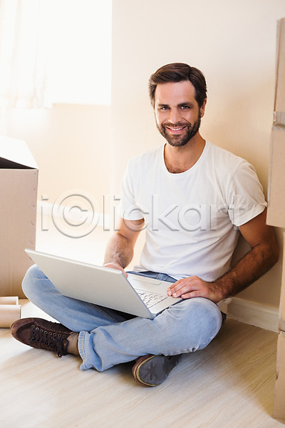 새로움 행복 30대 남자 백인 성인 한명 JPG 포토 해외이미지 가정 노트북 라이프스타일 미소(표정) 바닥 상자 실내 아파트 앉기 주택 캐주얼 컴퓨터 타이핑 해외202004