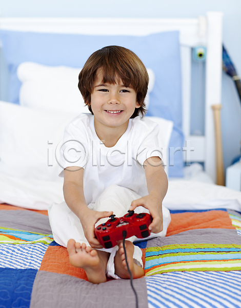 행복 흥분 남자 백인 사람 소년 소년한명만 어린이 한명 JPG 포토 해외이미지 가족 게임 놀이 미소(표정) 비디오게임 시스템 실내 앉기 주간 집콕 침대 침실 컴퓨터 테크노 표현 해외202004