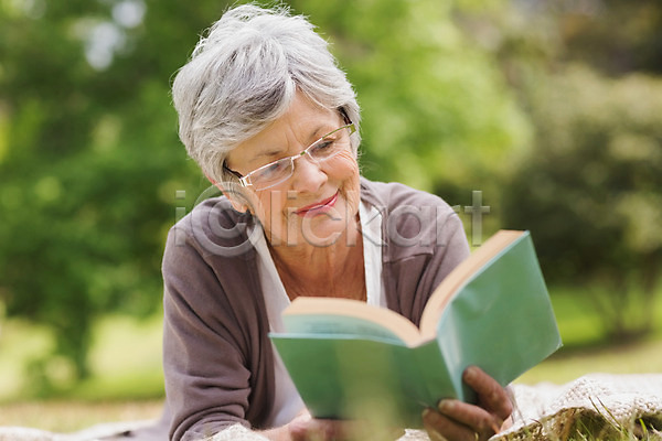집중 행복 휴식 70대 노년 백인 성인 여자 한명 JPG 포토 해외이미지 공원 나무 독서 라이프스타일 문학 미소(표정) 시골 안경 야외 은퇴 잔디 잡기 책 초록색 카펫 페이지 해외202004