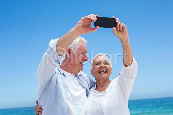 사랑 평화 함께함 행복 70대 남자 노년 노인만 두명 백인 여자 JPG 포토 해외이미지 노후 디지털카메라 맑음 모래 물 미소(표정) 바다 보여주기 사진촬영 스마트폰 스크린 여름(계절) 잡기 커플 파도 해외202004 휴가