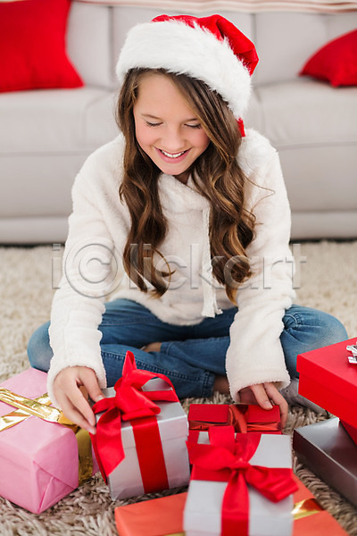 축하 행복 백인 어린이 여자 한명 JPG 포토 해외이미지 가정 거실 라이프스타일 미소(표정) 산타모자 선물 소파 실내 앉기 축제 크리스마스 펼침 해외202004