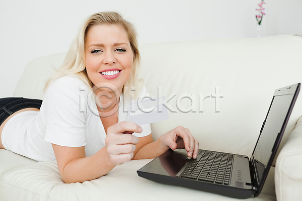 시원함 전자상거래 평화 행복 20대 백인 여자 한명 JPG 포토 해외이미지 거실 노트북 미소(표정) 선 소파 쇼핑 신용카드 실내 온라인 응시 인터넷 잡기 조용함 체크카드 컴퓨터 해외202004 흰색