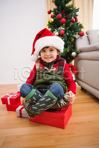 축하 행복 남자 백인 소년 어린이 한명 JPG 포토 해외이미지 가정 거실 라이프스타일 미소(표정) 산타모자 소파 실내 앉기 장식 장식볼 축제 크리스마스 크리스마스장식 크리스마스트리 포즈 해외202004